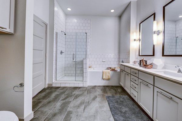 Bathroom with modern fixtures and elegant tilework at Agave Apartments