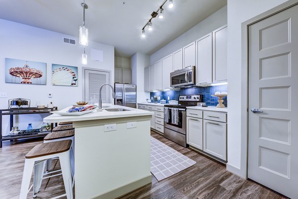 Modern kitchen with sleek countertops and stainless steel appliances at Agave Apartments luxury property