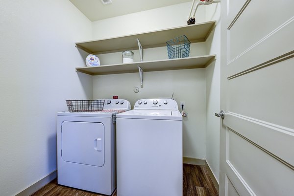 Laundry room with modern appliances and storage in Agave Apartments, offering convenient amenities for residents