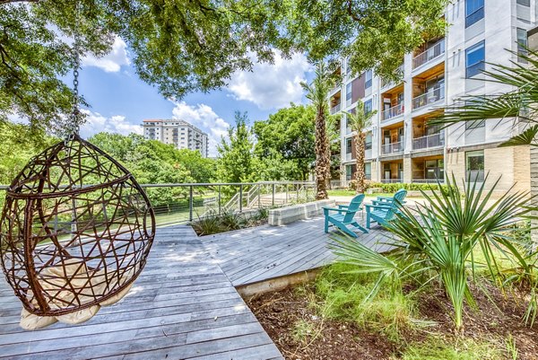 Charming outdoor patio with seating and greenery at Agave Apartments