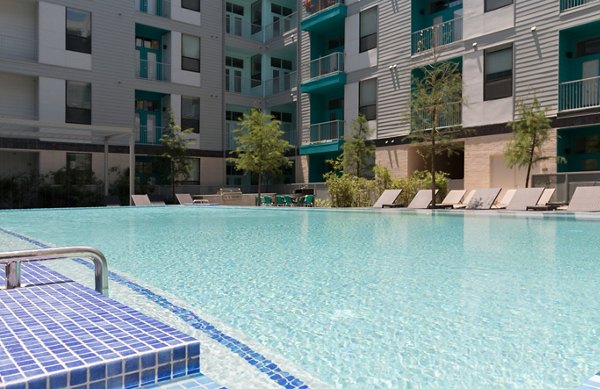 Sunlit lounge chairs by pool at Agave Apartments, a luxury community offering resort-style amenities in a serene setting