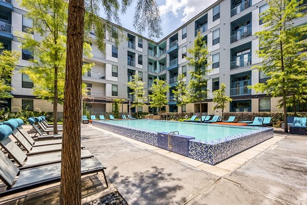 Resort-style pool with lounge chairs at Agave Apartments, a luxury living community