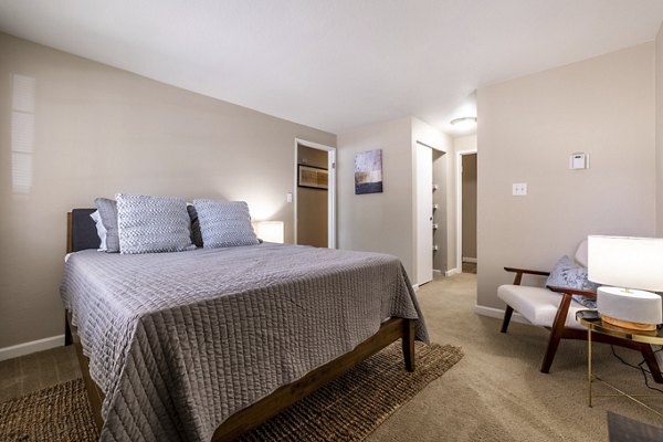 Cozy bedroom with stylish decor at The Seasons Apartments, offering modern comforts and luxury living