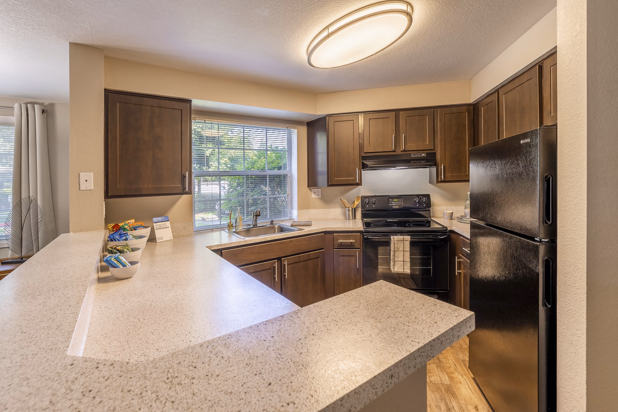 Modern kitchen with stainless steel appliances and island at The Seasons Apartments