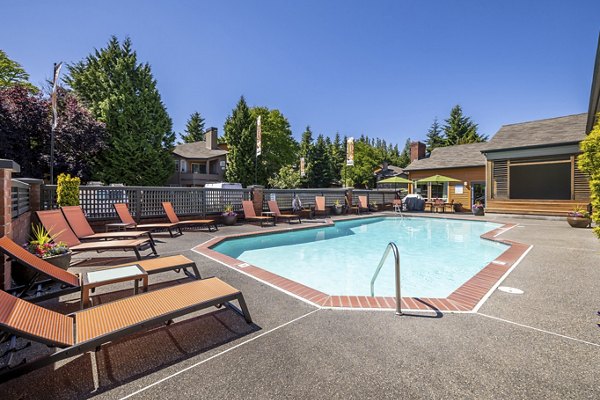 Sunlit outdoor pool at The Seasons Apartments with surrounding lounge chairs
