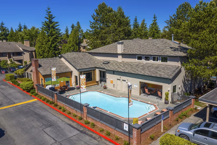 Luxurious outdoor pool with lounge seating at The Seasons Apartments
