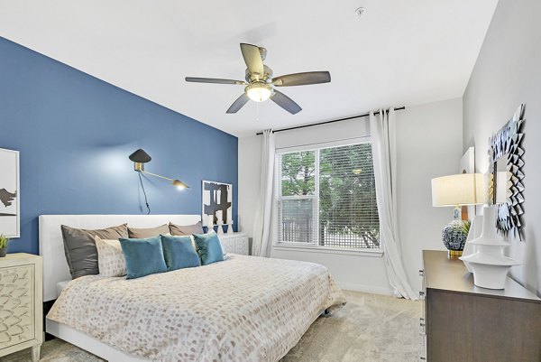 Cozy bedroom with modern furnishings at Oak & Ellum Apartments, offering a luxurious living experience in the Greystar community