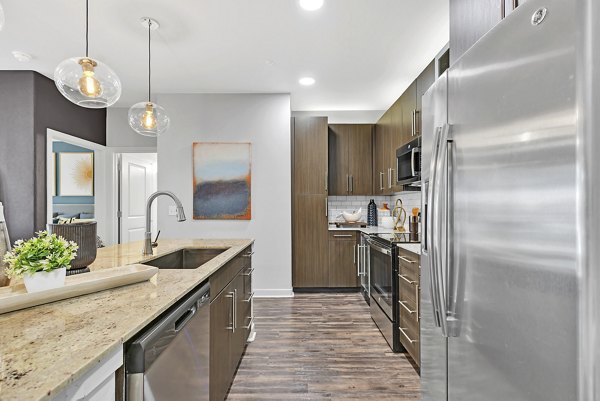Kitchen with modern appliances and sleek countertops at Oak & Ellum Apartments A luxurious space for culinary delight in Greystar's premium property