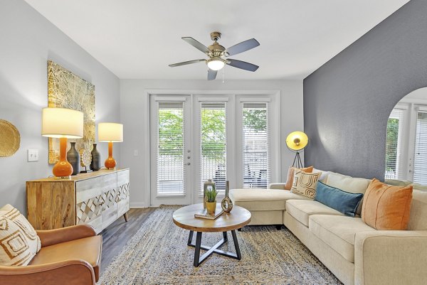 Modern living room with plush seating and vibrant artwork at Oak & Ellum Apartments, a Greystar luxury residence