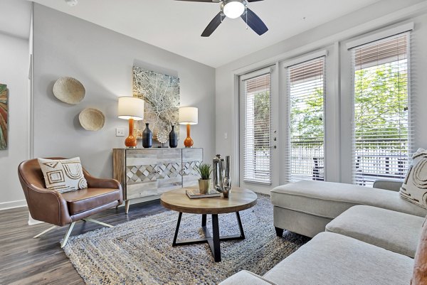 Spacious living room with modern decor and large windows at Oak & Ellum Apartments, offering luxurious living spaces in the heart of the city