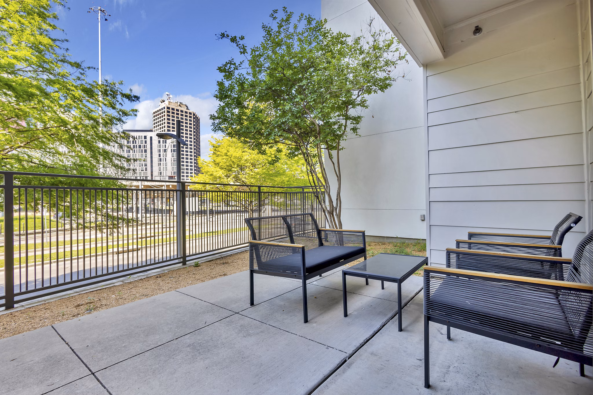 Modern outdoor patio at Oak & Ellum Apartments with stylish seating and greenery, perfect for relaxation and social gatherings