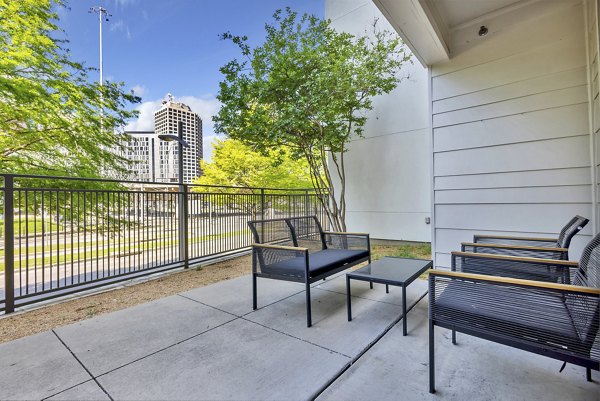 Modern outdoor patio at Oak & Ellum Apartments with stylish seating and greenery, perfect for relaxation and social gatherings