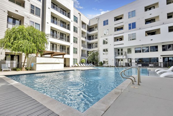 Relaxing pool area at Oak & Ellum Apartments with surrounding lounge chairs