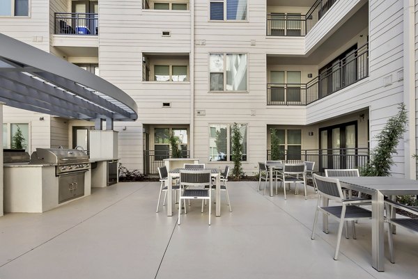 Spacious outdoor grill area with modern seating at Oak & Ellum Apartments offering luxury lifestyle amenities