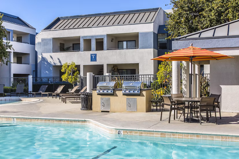 Luxurious pool at Avana Rancho Cucamonga Apartments featuring sun loungers and palm trees, perfect for relaxing in the California sun