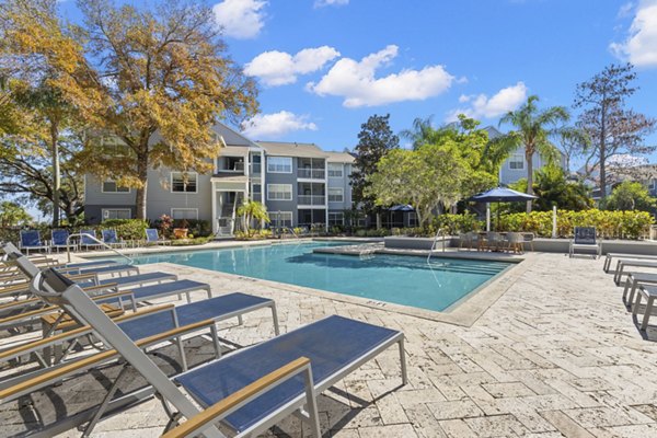 Relaxing pool area with lounge chairs at Avana City Park Apartments, a Greystar luxury apartment community