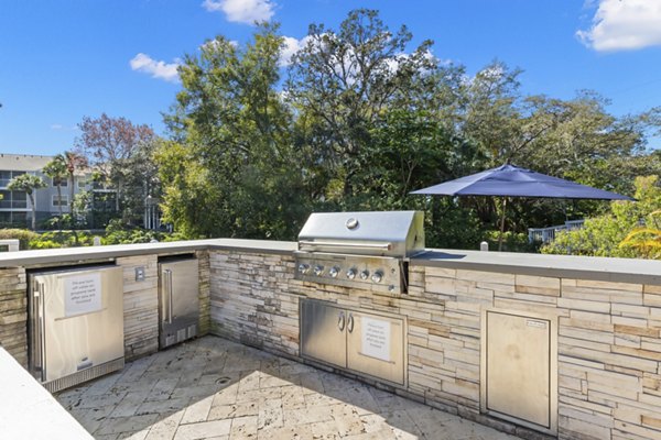 Outdoor grill area/patio featuring modern seating at Avana City Park Apartments for residents to enjoy casual gatherings and cookouts