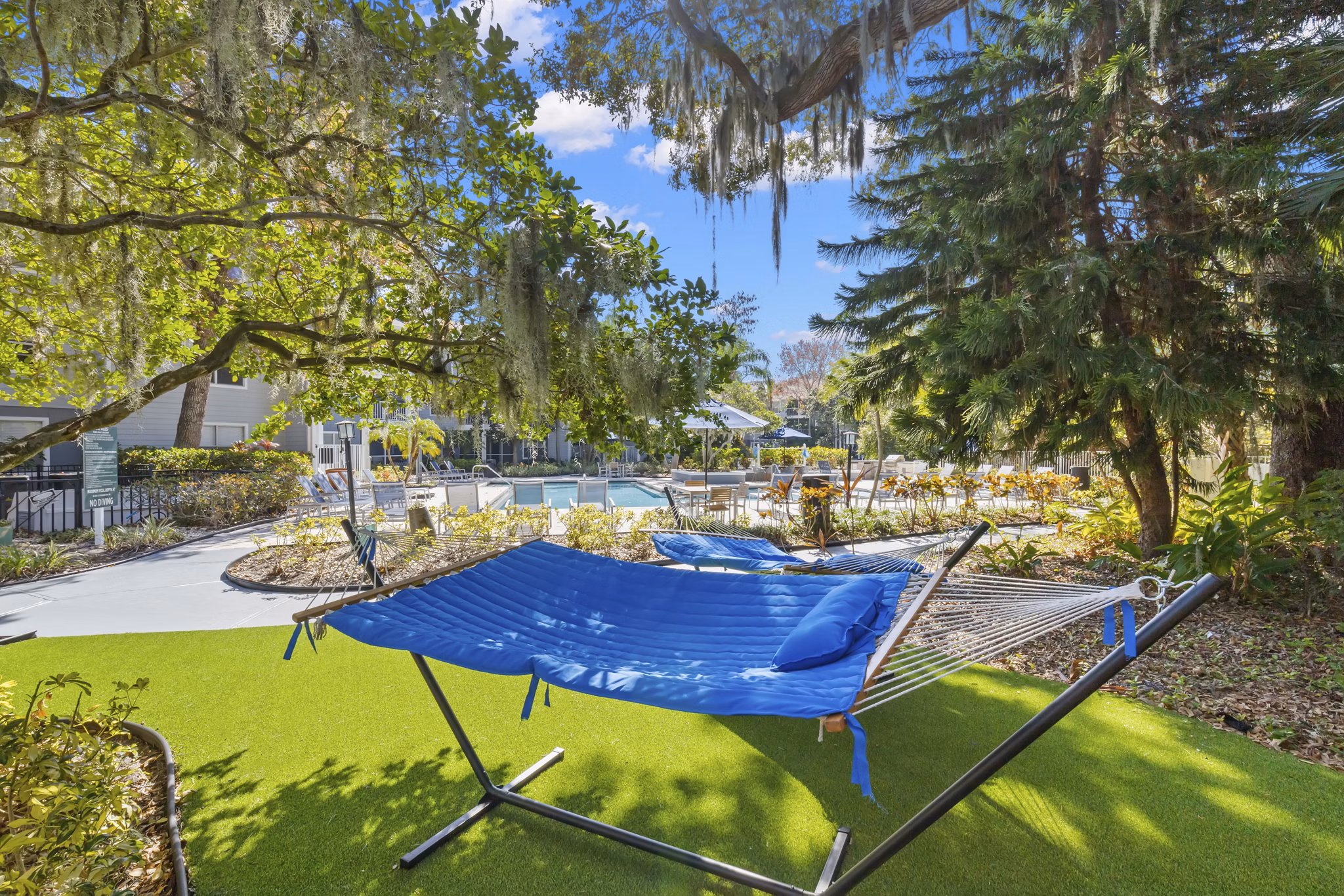 Relaxing hammock area in lush courtyard at Avana City Park Apartments, ideal for outdoor lounging and leisure activities