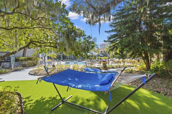 Relaxing hammock area in lush courtyard at Avana City Park Apartments, ideal for outdoor lounging and leisure activities