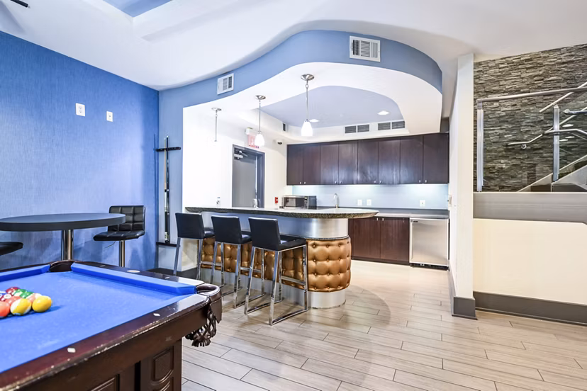 Clubhouse game room featuring pool table and lounge seating at The Stories Apartments, offering vibrant social spaces for resident gatherings