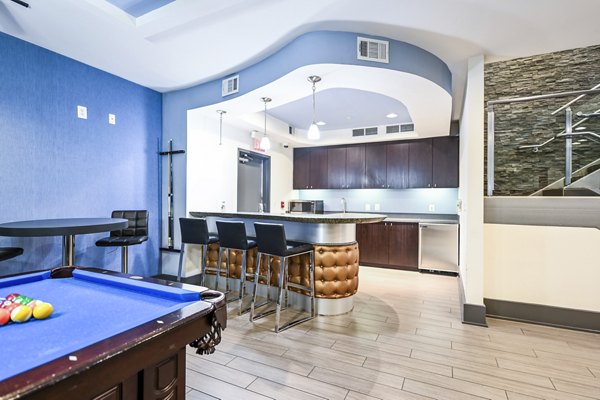 Clubhouse game room featuring pool table and lounge seating at The Stories Apartments, offering vibrant social spaces for resident gatherings