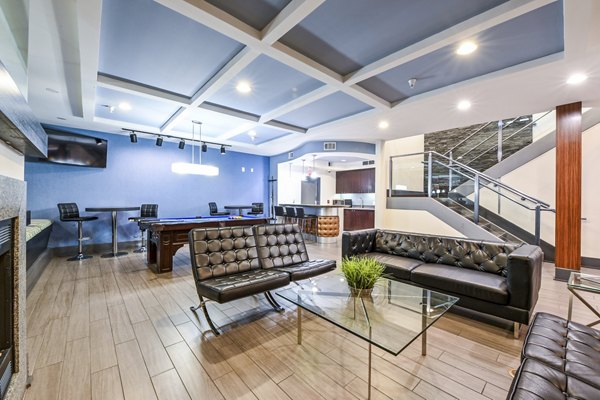 Clubhouse game room featuring pool table and modern seating at The Stories Apartments