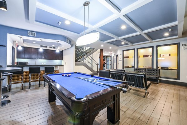 Clubhouse game room featuring billiards and lounge seating at The Stories Apartments