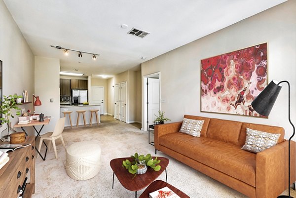 Living room with modern furnishings and large windows at The Stories Apartments