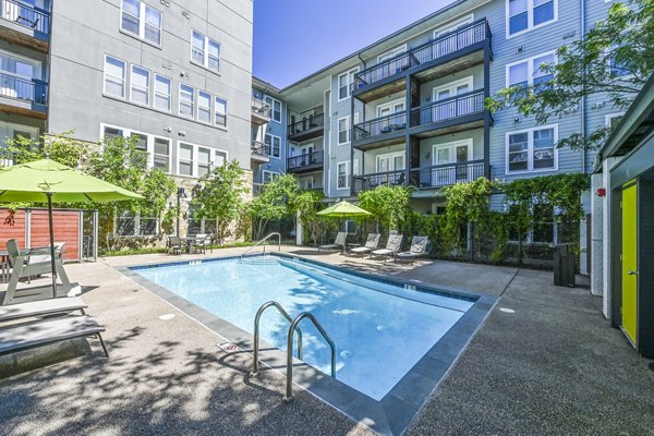 Rooftop pool with sun loungers at The Stories Apartments, luxury living with city views