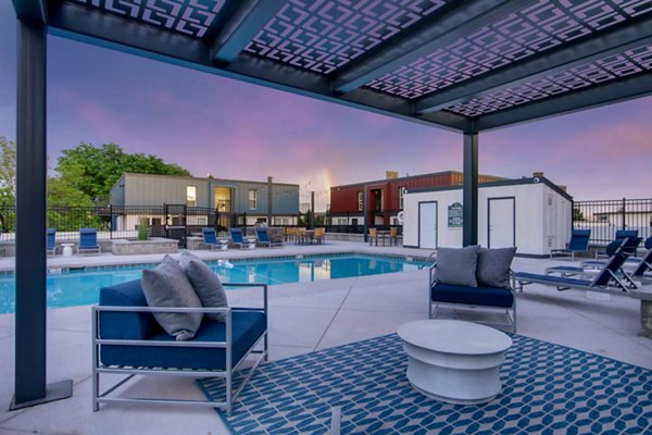 Relaxing outdoor pool with lounge chairs and lush landscaping at Copperwood Apartments, a luxury residence by Greystar