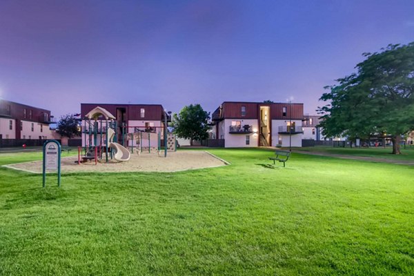 Children's playground with slides and swings at Copperwood Apartments, offering family-friendly amenities in a welcoming community