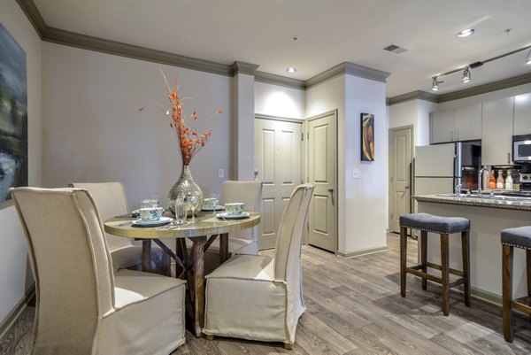 Dining room with modern decor and large windows at Avana Uptown Apartments