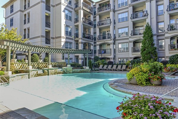 Relaxing outdoor pool area with sun loungers at Avana Uptown Apartments, ideal for luxury living in a vibrant urban setting