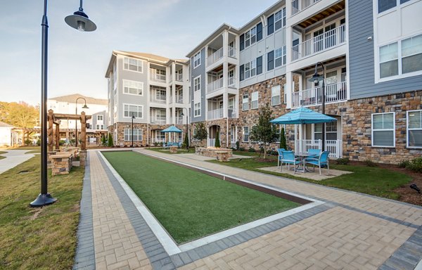Serene courtyard with lush greenery at Element Ballantyne Apartments, offering tranquil outdoor living in a luxury setting