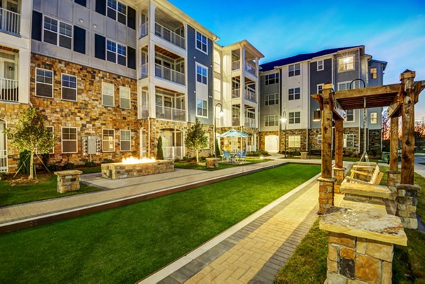 Lush courtyard with seating and pathways at Element Ballantyne Apartments