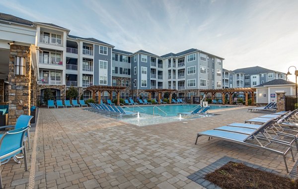 Luxurious pool with lounge chairs at Element Ballantyne Apartments