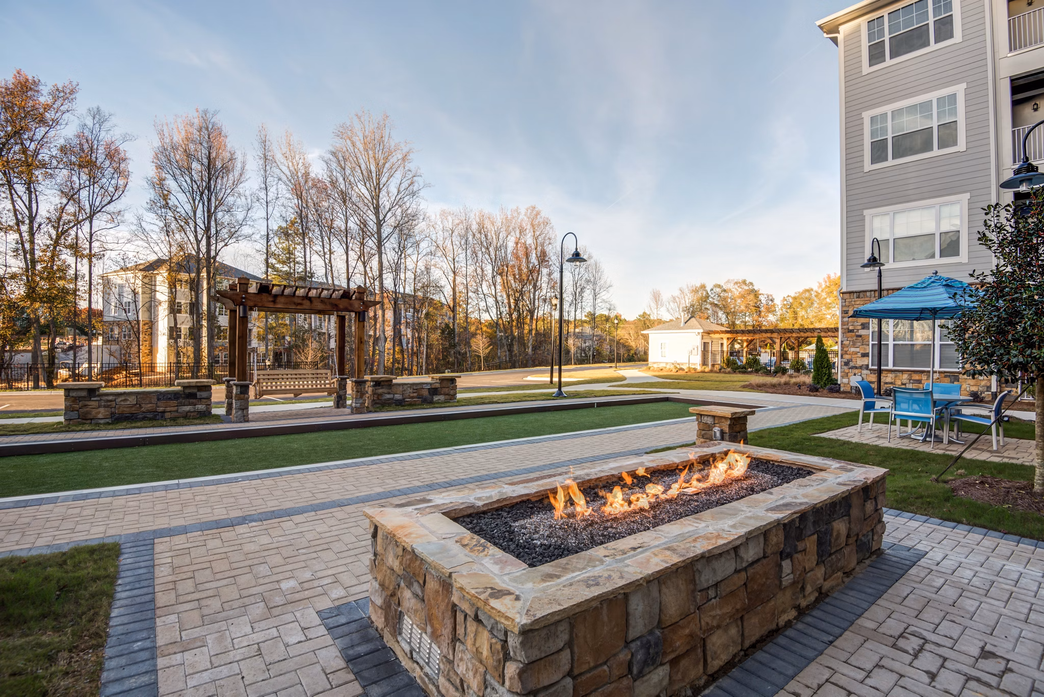 Outdoor fire pit area at Element Ballantyne Apartments, luxury rental community with social seating and ambient lighting