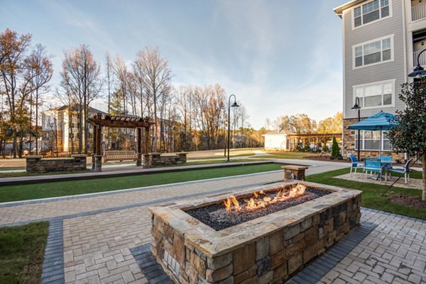 Outdoor fire pit area at Element Ballantyne Apartments, luxury rental community with social seating and ambient lighting