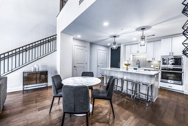 Dining room with elegant light fixtures at Novel River Oaks Apartments, showcasing modern design and spacious seating area
