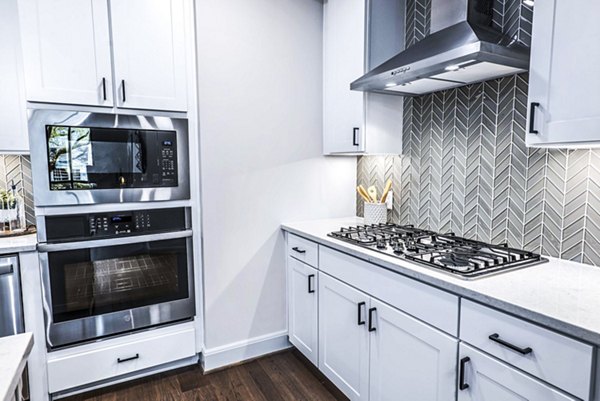 Modern kitchen with island and stainless steel appliances in Novel River Oaks Apartments