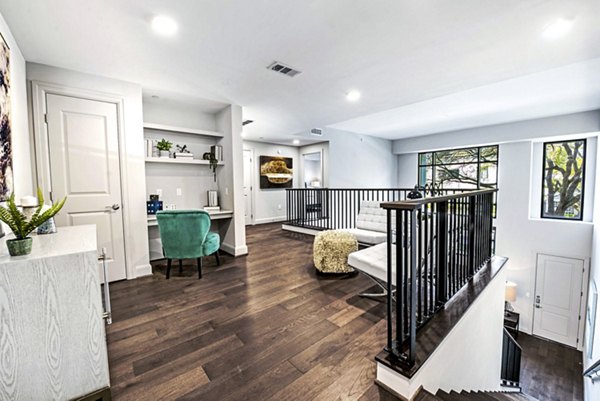 Upstairs living room/office with natural light and modern decor at Novel River Oaks Apartments
