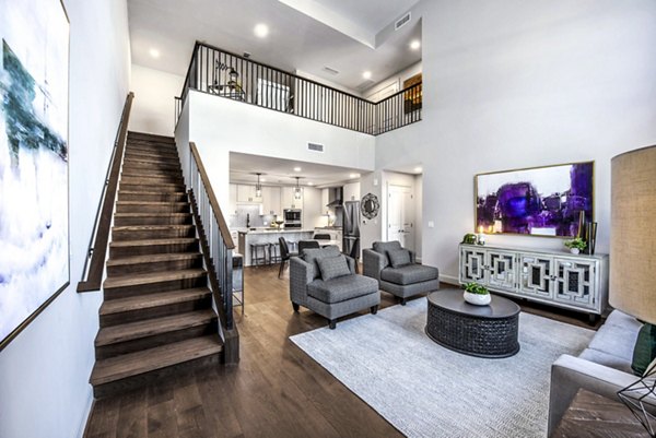 Living room with modern decor and large windows at Novel River Oaks Apartments