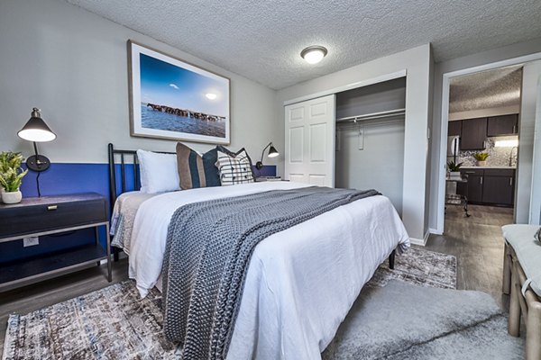The Lodge Apartment Homes: Cozy bedroom with plush bedding and natural light