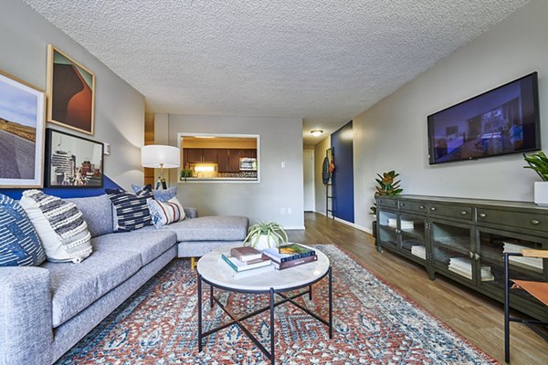 Spacious living room featuring modern decor and ample natural light at The Lodge Apartment Homes