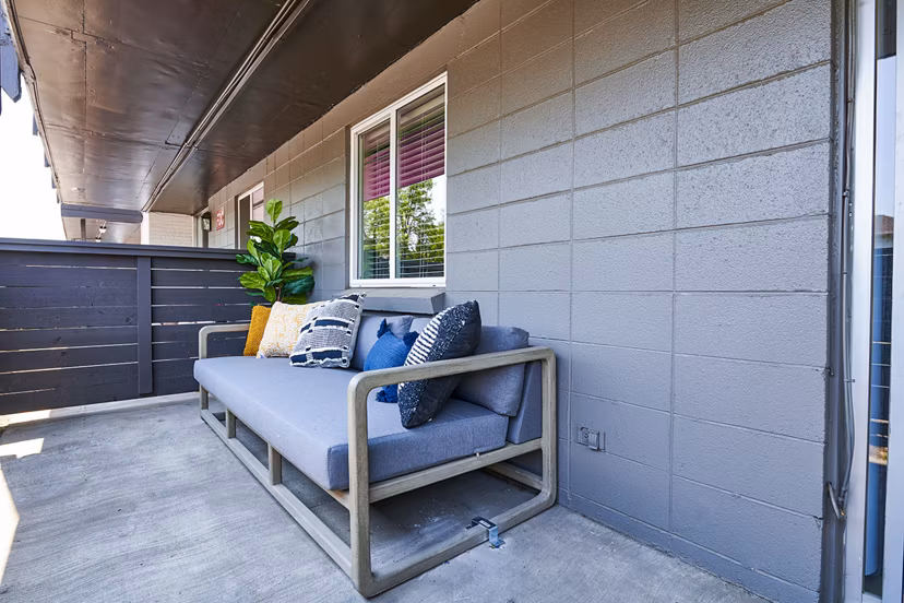 Patio with modern furniture and greenery at The Lodge Apartment Homes in prime location for luxury living