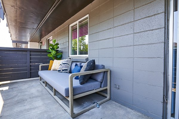 Patio with modern furniture and greenery at The Lodge Apartment Homes in prime location for luxury living