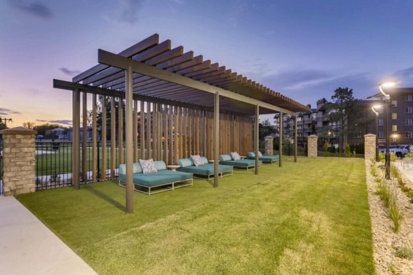 The Lodge Apartment Homes: Relaxing patio area with seating and greenery, ideal for outdoor leisure in a luxury setting