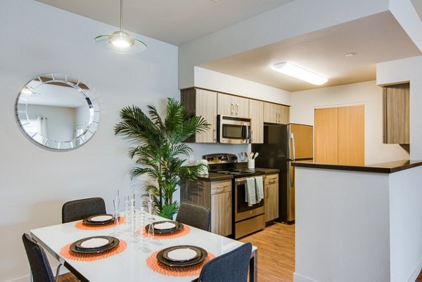 Modern kitchen featuring stainless steel appliances and granite countertops at The Bailey at Amazon Creek Apartments