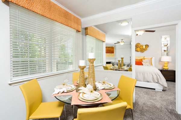 Dining room with elegant wooden furniture and modern lighting at Aspen Ridge Apartments