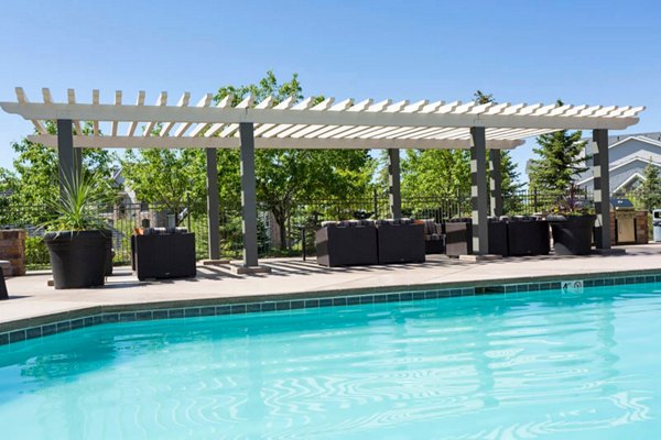 Pool with lounge chairs at Aspen Ridge Apartments offering residents outdoor relaxation and recreation